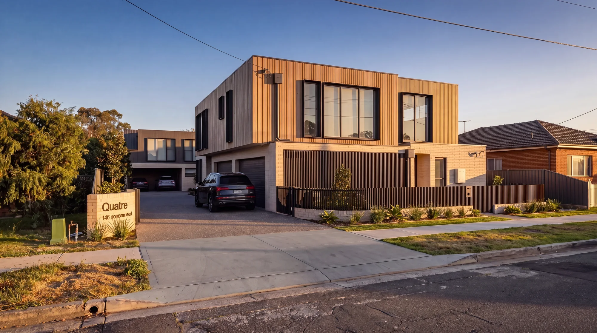 Made two-storey town houses in brick and timber cladding with a shared driveway, golden hour